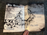 Open book with dark fantasy illustrations and text on a textured surface