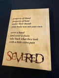 Text on a textured surface with the word 'SEVERED' in large letters.