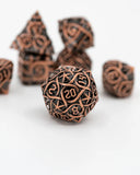 Set of intricately designed copper-colored dice on a white background