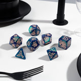 Set of blue and purple dice with intricate designs on a white surface.