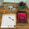 Calendar, dice set, and Dungeon Master's Guide on a wooden surface