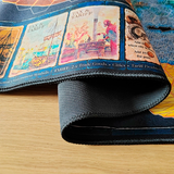 Roll of black tape on a wooden surface with a colorful book or map in the background
