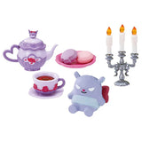 Set of toy tea set with teapot, cups, cookies, and a character figure on a white background