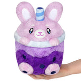 Plush toy with bunny design held in a hand on a white background