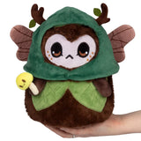 Plush toy owl with green hood and wings held by a hand on a white background