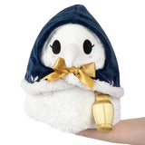 Plush toy with a navy hood, white face, and gold bow and lantern on a white background
