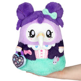 Plush toy with purple hair and a green outfit held by a hand