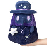 Plush toy with a blue hat and purple scarf, held by a hand on a white background