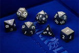 Set of polyhedral dice on a blue surface with a brand logo.