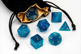 Set of blue polyhedral dice with gold numbers on a white background