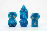 Set of blue polyhedral dice with gold numbers on a white background