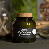 Candle jar labeled 'Nightshade' with a cork lid on a dark surface.
