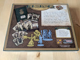 Board game set with miniatures and cards on a display board, featuring CMON logos.