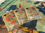 Board game with tarot card-themed cards on a map-like board