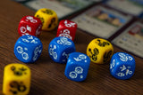 Colorful dice with game pieces on a wooden table