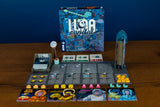 Board game setup with 'Luna Capital' box on a wooden surface
