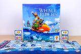 Board game 'Whale Riders' with colorful artwork on the box and game pieces on a blue mat.