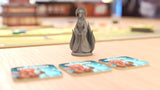 Board game piece and cards on a table with a blurred background