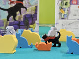 Colorful cat-shaped wooden toys on a blue surface with a blurred background