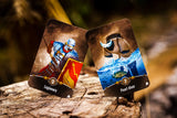 Two playing cards featuring a Legionary and a Pearl diver on a wooden surface with a blurred natural background.