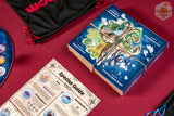 Board game components including a box, species guide, and cards on a red surface