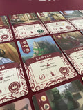 Close-up of game cards with detailed artwork and text on a red surface