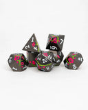 Set of black polyhedral dice with floral designs on a white background