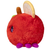 Red plush toy with yellow fruit slice ears on a white background