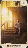 Man sitting on a wooden staircase with a lantern, surrounded by trees, with 'The Emperor' text at the bottom.
