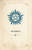 A square card or print with a parchment-like beige background, featuring a blue sunburst pentagram symbol at the top and the text 'THIS BELONGS TO' with a small matching symbol below.