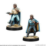 Two miniature figures of a character in a blue cape with a gun, on black bases.