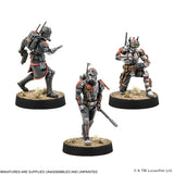 Three miniature figures on stands with a white background