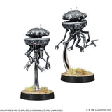 Two miniature robot figures on stands with a white background