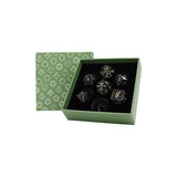 Set of dice with metallic sheen in a green box with geometric pattern
