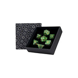 Set of green dice with a black box and patterned card on a white background