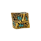 Gold metal dice with turquoise numbers on a white background