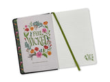 Open notebook with floral design and text on cover, green binding