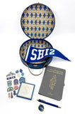 Collection of 'SHIZ' themed items including a hat box, notebook, and decorative items on a white background.